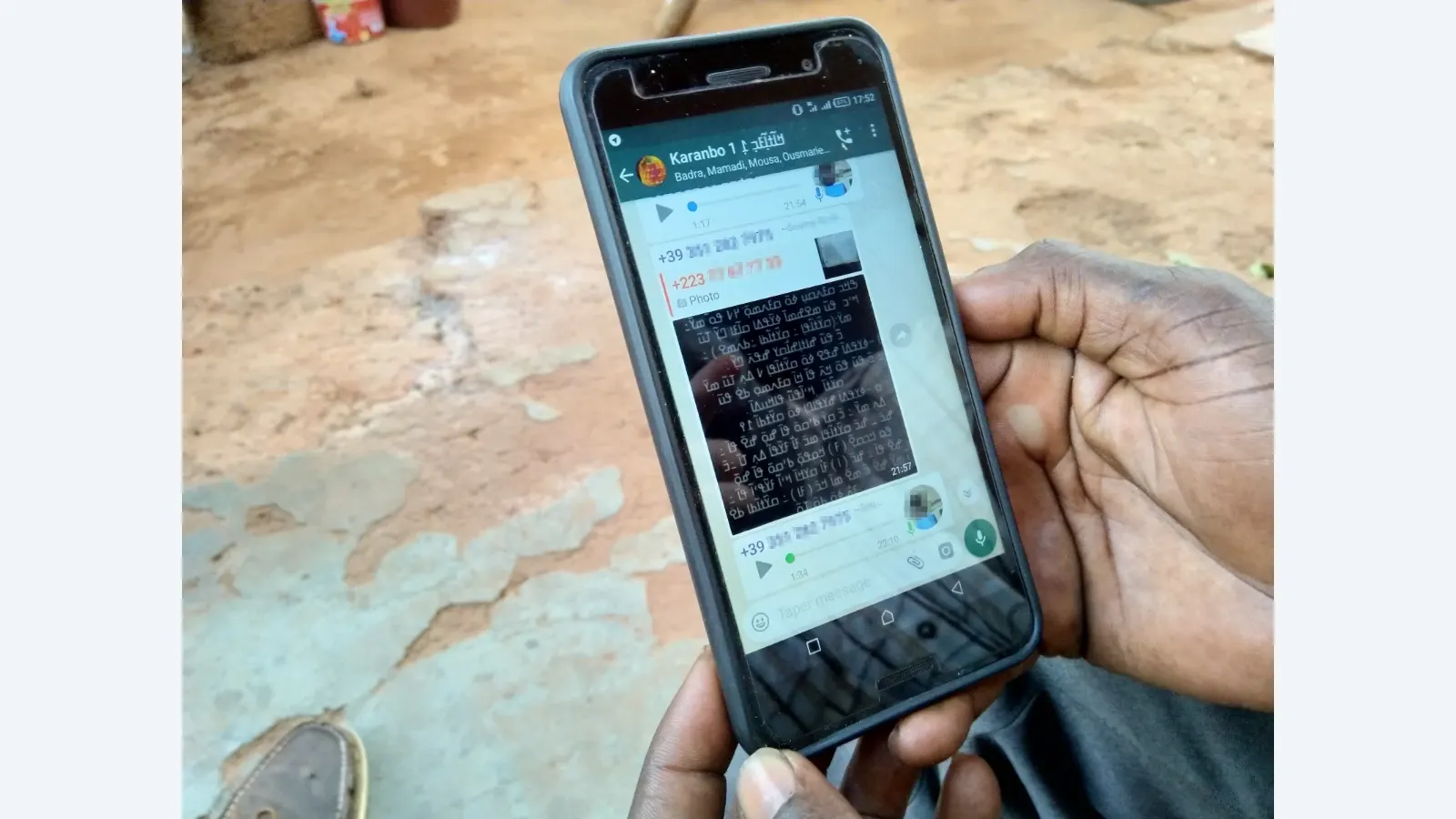 Foto ilustrativa de arquivo — A picture of a man holding his cellphone in which one can view an online WhatsApp-based NKo classroom with the phone numbers and faces of users blurred out